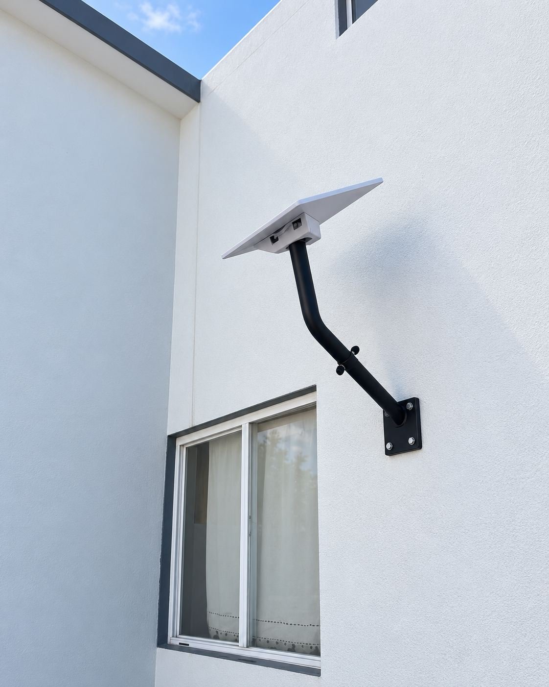 Antena Starlink en brazo de soporte negro fijado a un muro blanco